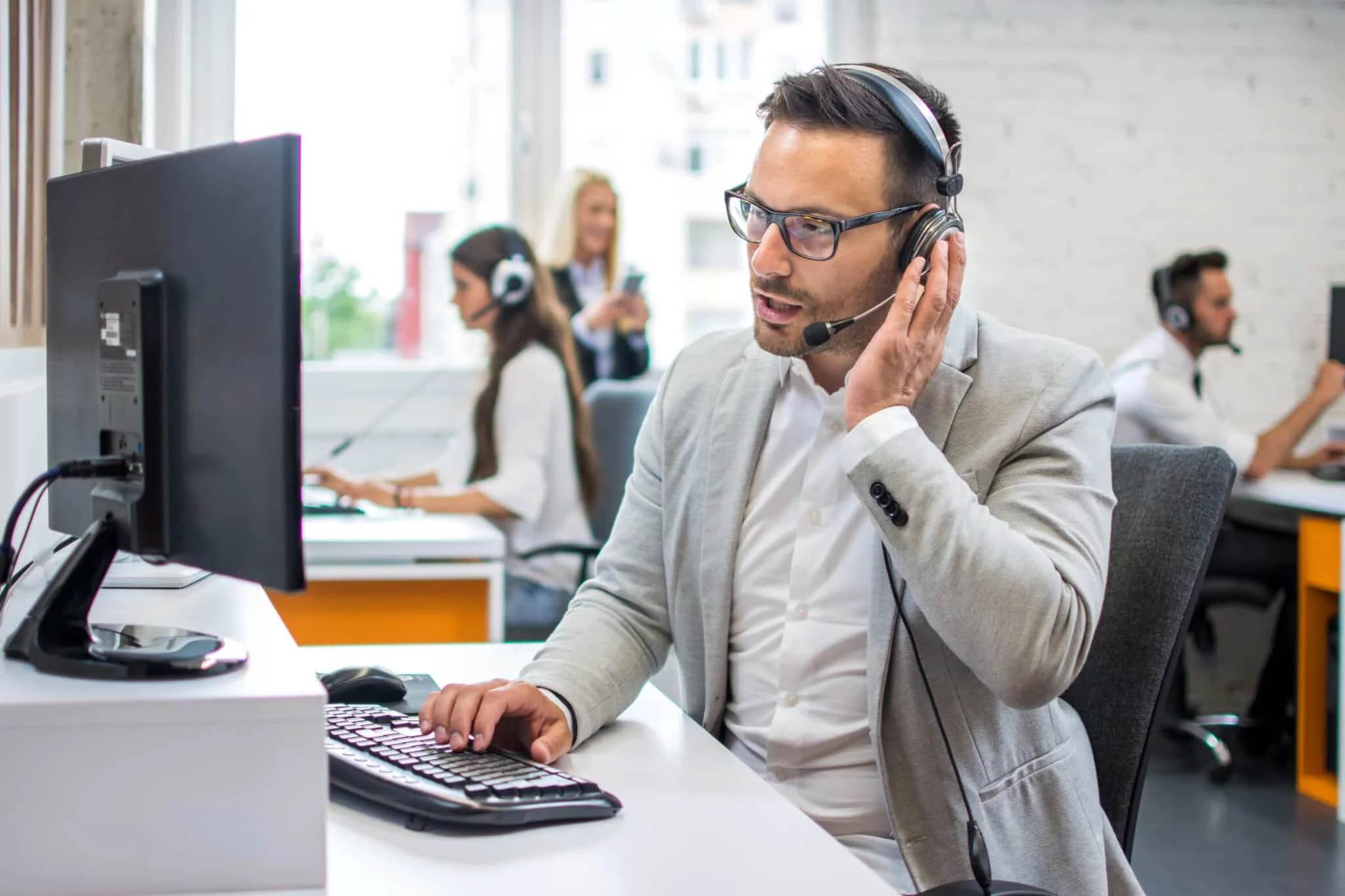 Innesäljare med headset vid datorn